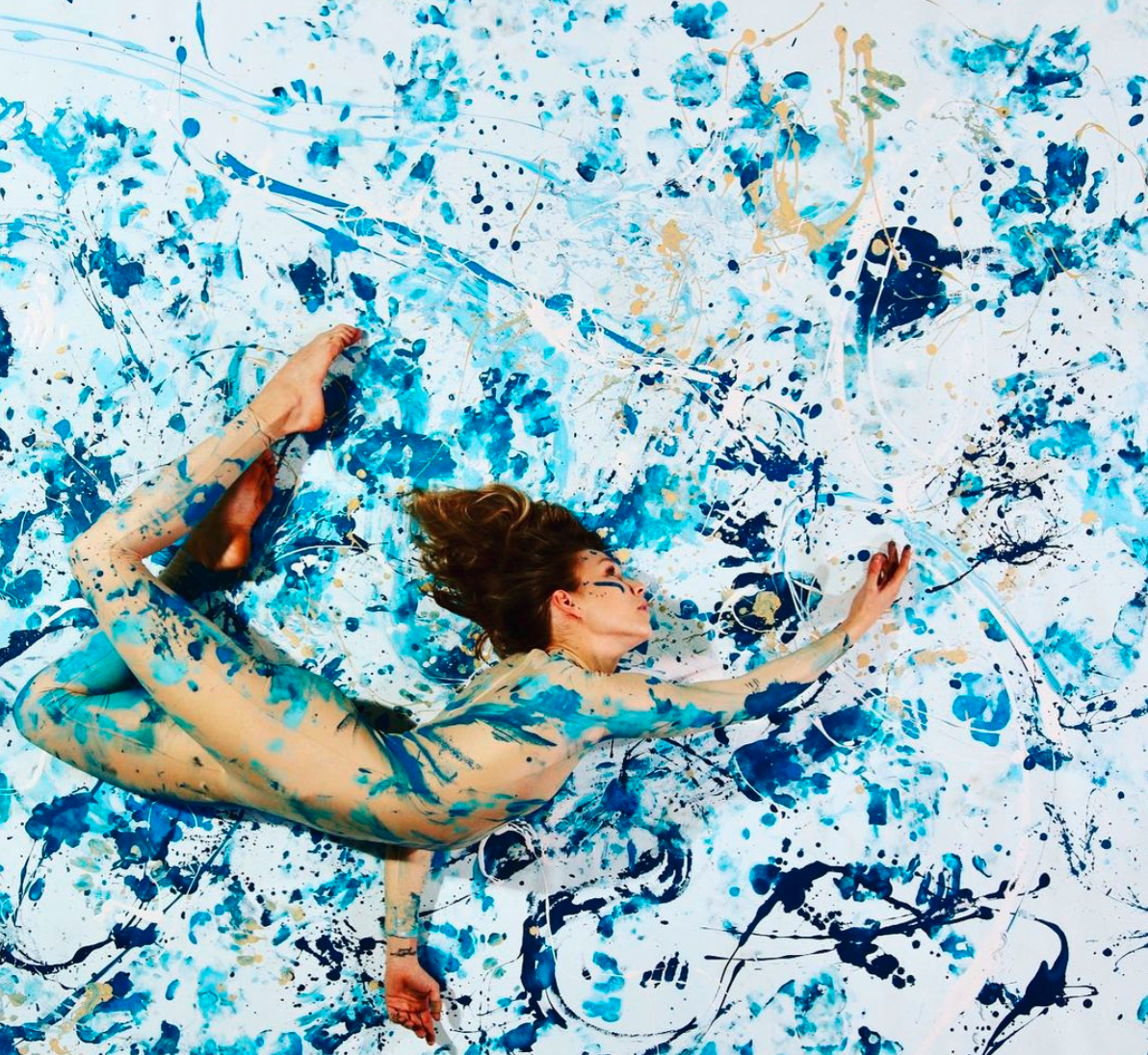 An image of Annika Rhea conducting a live dance-painting performance. 