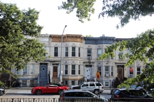 Row of houses with cars in front of them